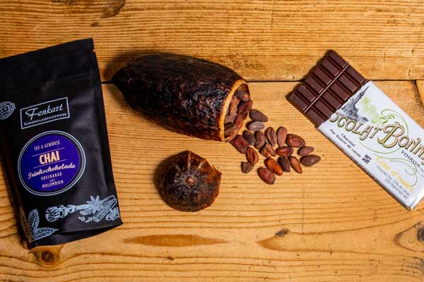 Trinkschokolade der Kaffeerösterei Kirmse neben Schokolade und Kakaobohnen